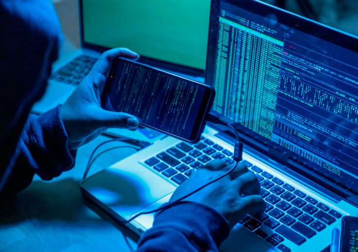 Ein Symbolbild zu dem Handelsblatt-Artikel "Sind Cyberrisiken in Zeiten von KI noch versicherbar?" zeigt einen Hacker bei seiner Arbeit