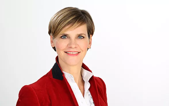 Franka Barsch, Head of Claims Europe, trägt einen roten Blazer und lächelt in die Kamera.