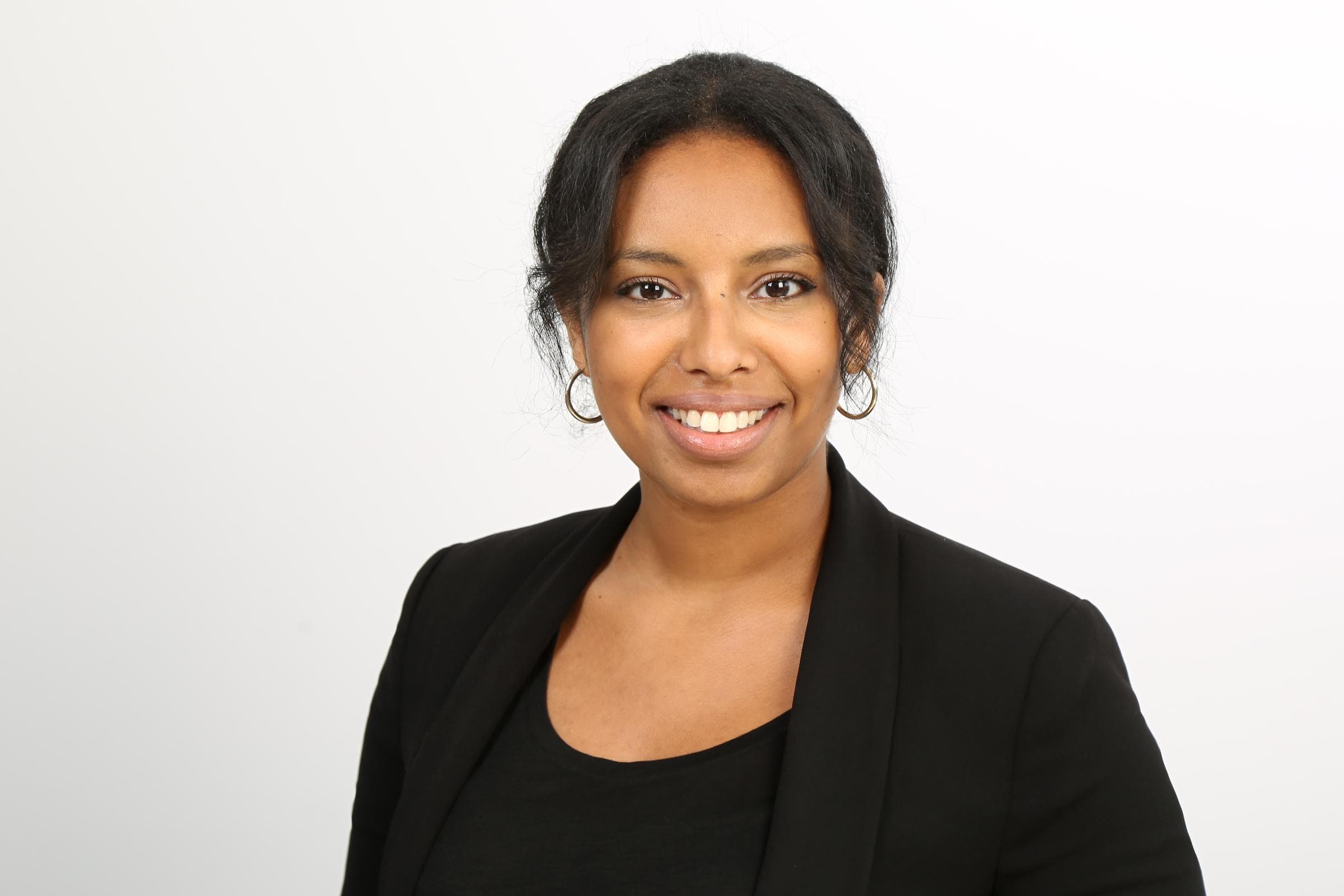 Semret Haile trägt einen schwarzen Blazer und ein schwarzes Oberteil. 