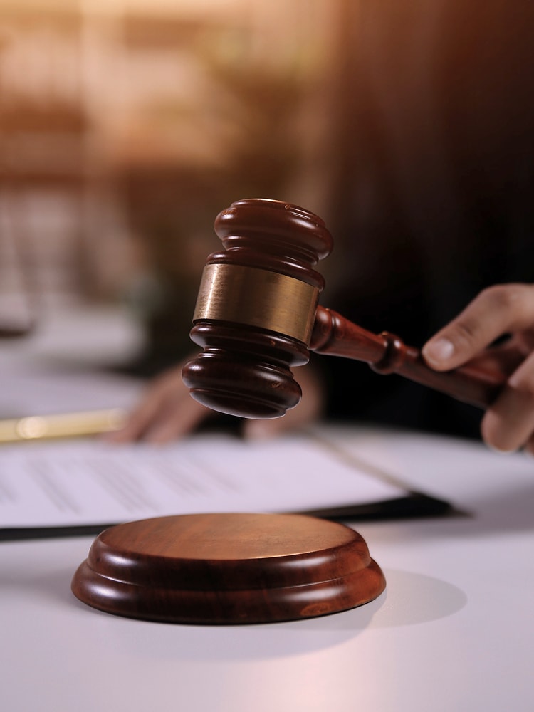 Auktionshammer, der über einem Blatt Papier geschwungen wird