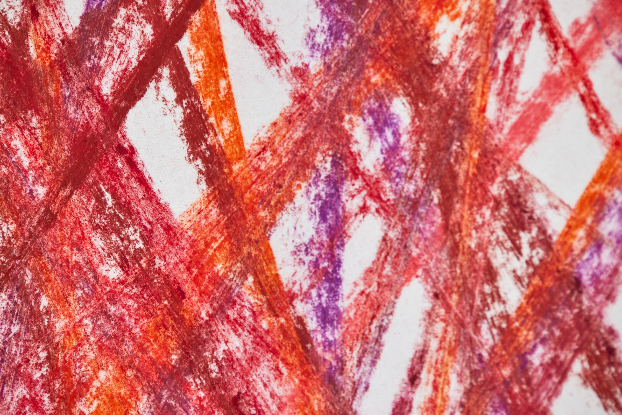 Das Bild zeigt eine Nahaufname von einem Kunstwerk, deren Linien mit Kreidefarben in verschiedenen Rottönen und lila Farbe gezeichnet sind.