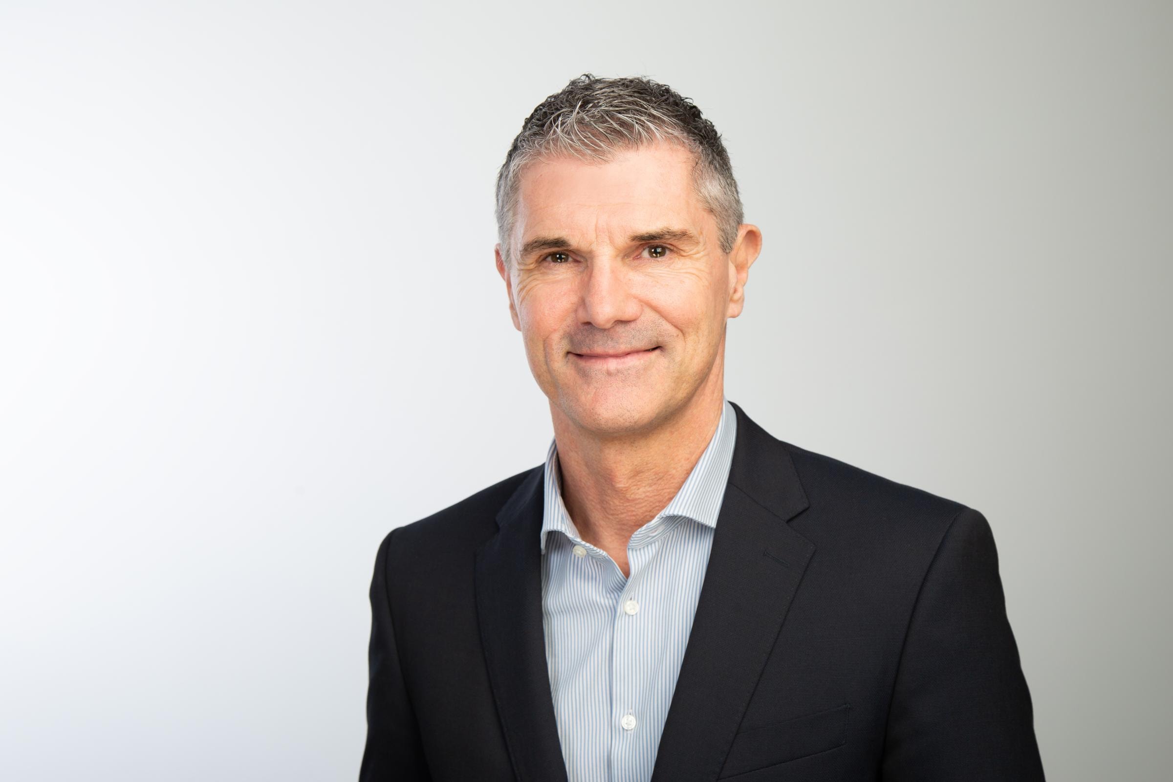 Hiscox Underwriter Markus Rupp trägt ein Sakko und lächelt in die Kamera.