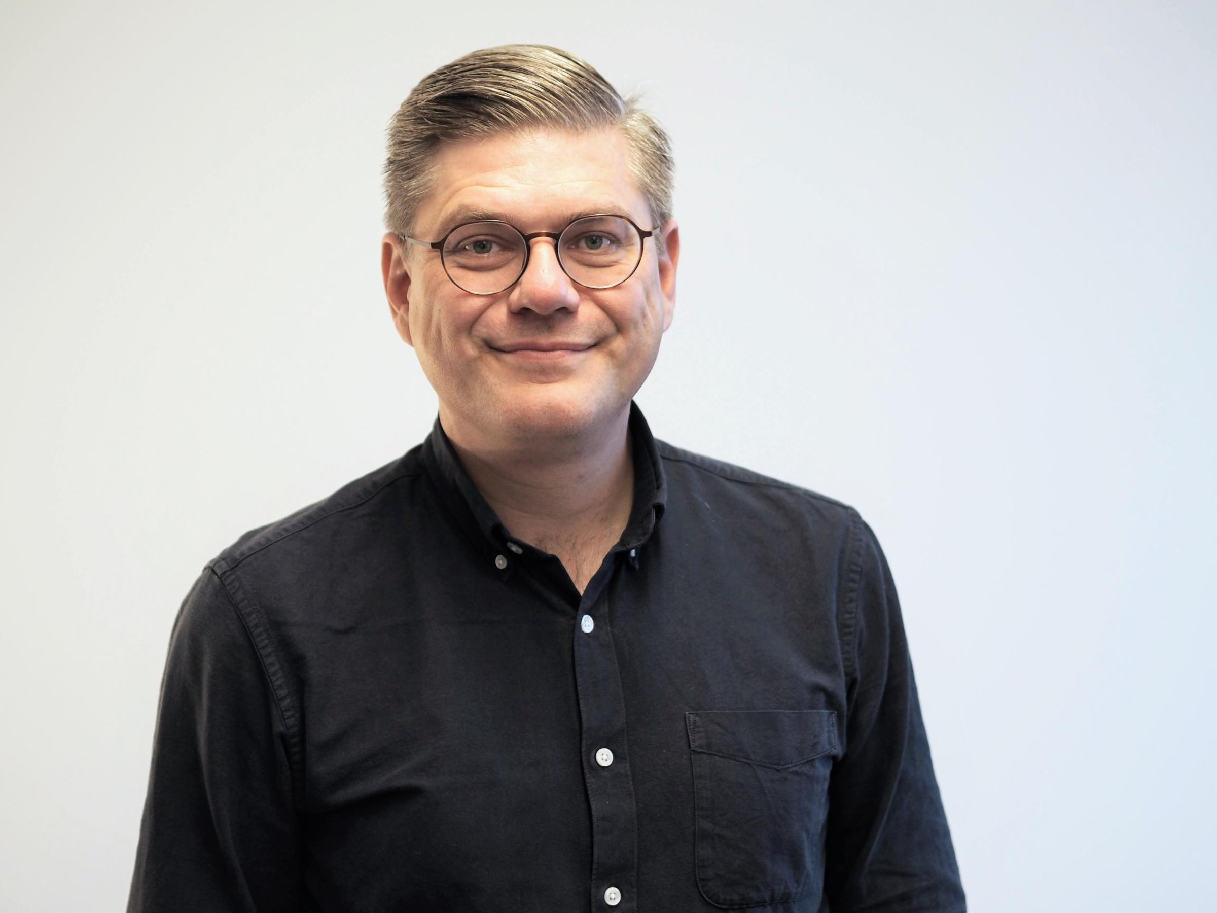 Der HR-Experte Martin Schmeisser trägt gescheiteltes Haar, eine Brille und lächelt in die Kamera.