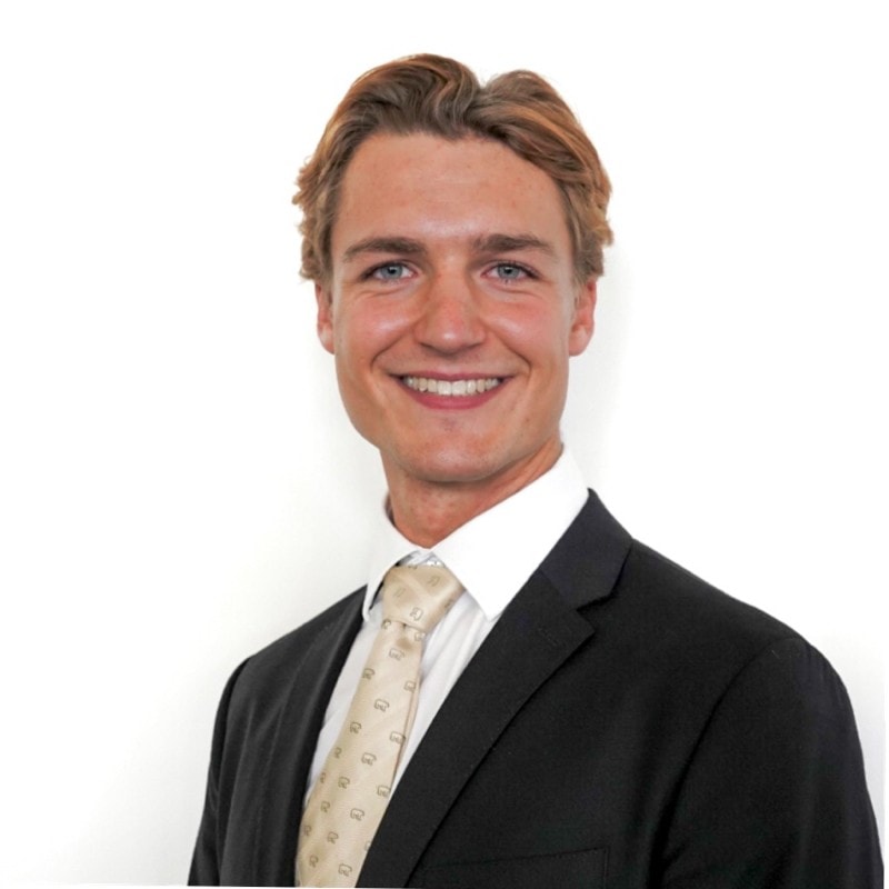 Nils Woyna, ein junger Mann mit Anzug und Krawatte, ist als Underwriter bei Hiscox tätig