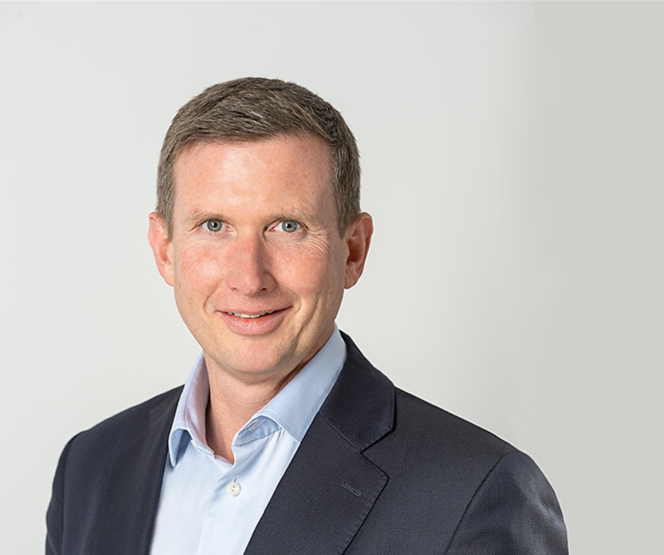 Robert Dietrich ist der CEO von Hiscox Europa. Er trägt ein Hemd und Sakko und lächelt in die Kamera