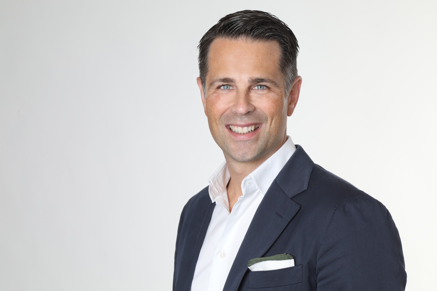 Das Bild zeigt den zukünftigen Deutschlandchef Tim Bethge, einen lächelnden Mittvierziger mit Hemd und Sakko.