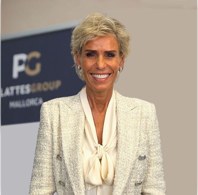 Yvonne Plattes, Gründerin der PlattesGroup und Leiterin der Rechtsabteilung, trägt einen weißes Blazer und eine weiße Bluse mit Schleife. Sie hat kurze blonde Haare und lächelt in die Kamera. 