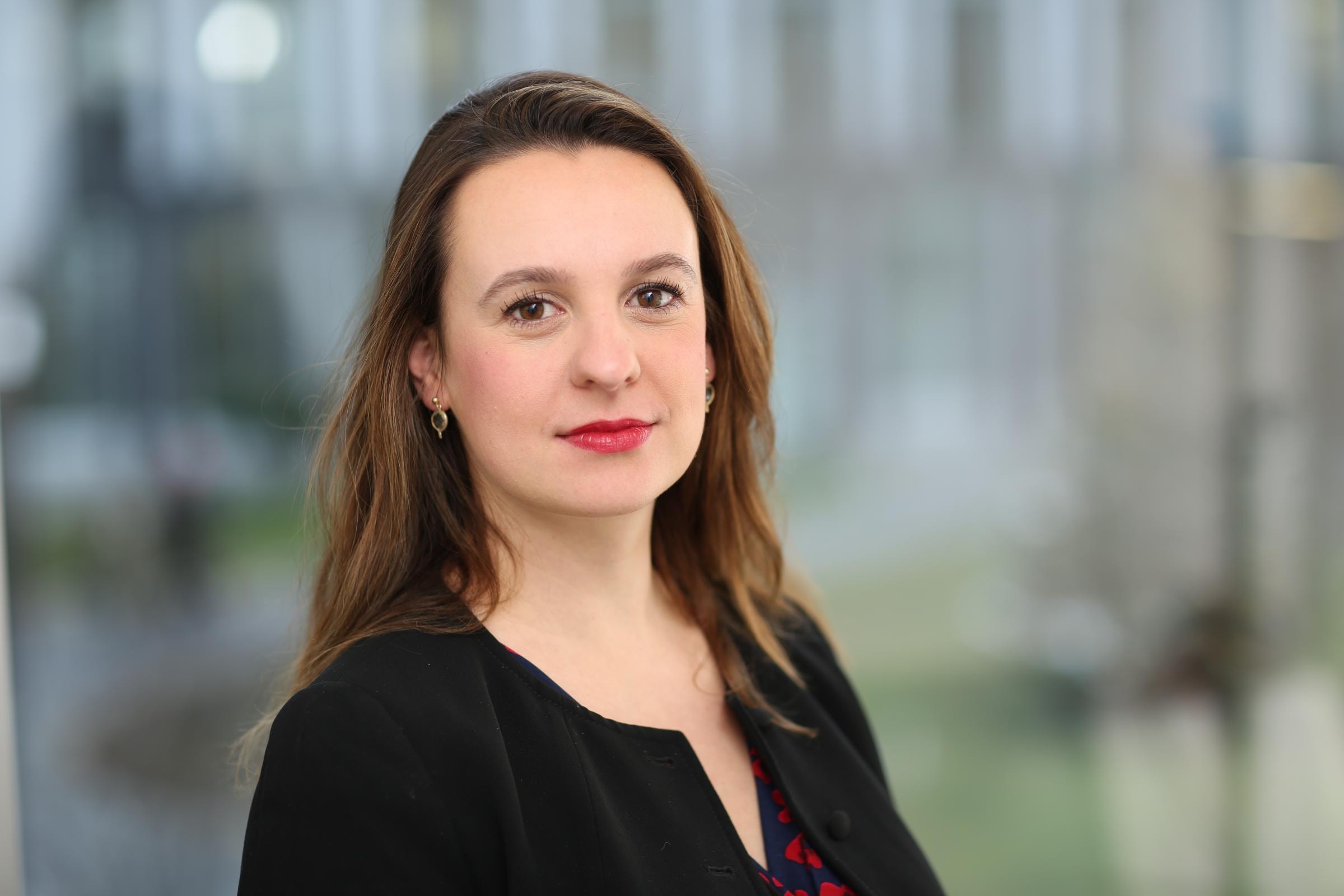 Alina Sucker mit rotem Lippenstift und schwarzer Blazer bei der Arbeit für Hiscox - Head of Art & Private Clients, Property & Event