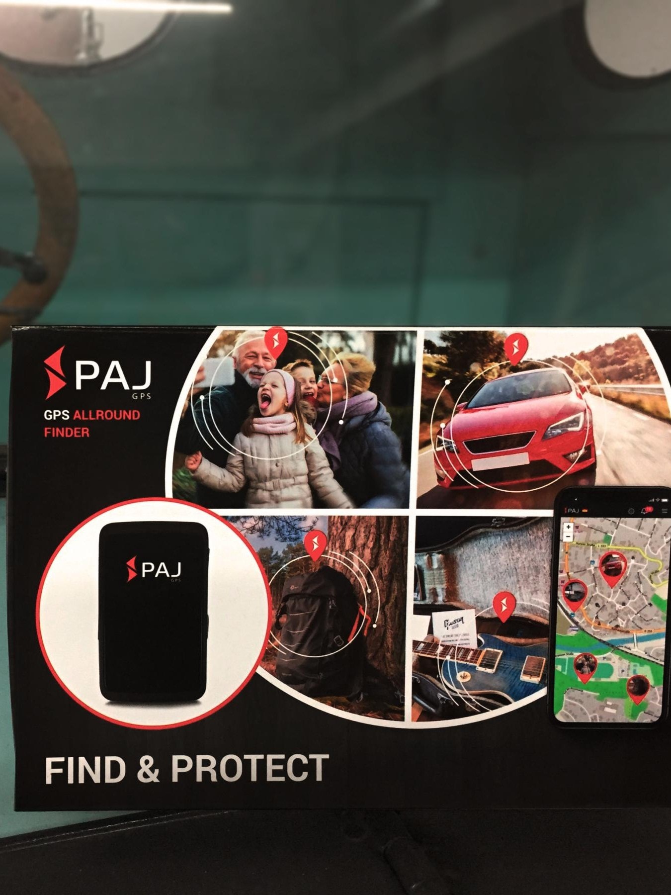 Ein türkiser Oldtimer mit einem Schild, welches die Werbung für den GPS-Tracker "PAJ" zeigt.