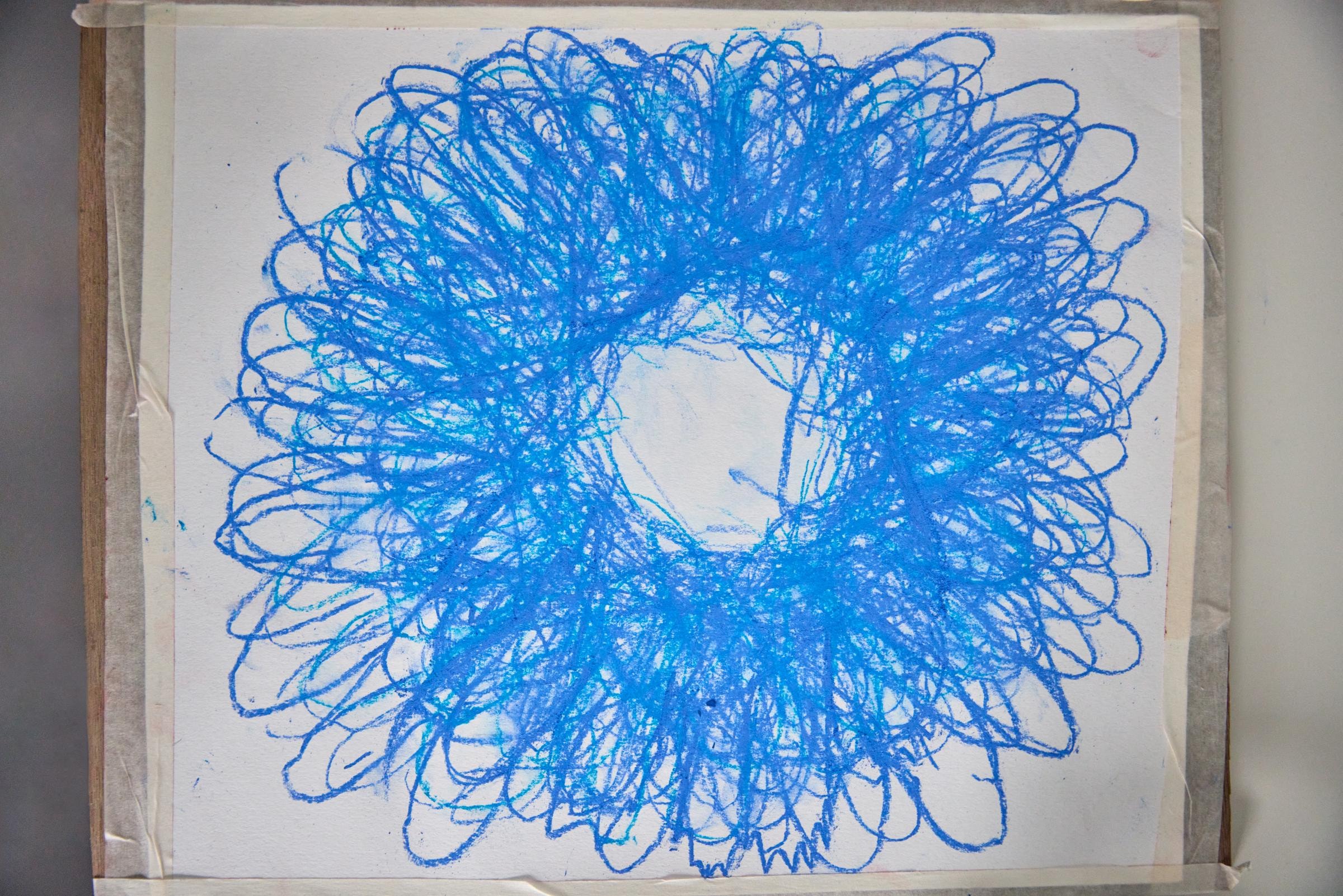 Das quadratische Kunstwerk zeigt eine blumenartige Figur, die aus den Umrissen der Hände von vielen Menschen entstanden ist. 