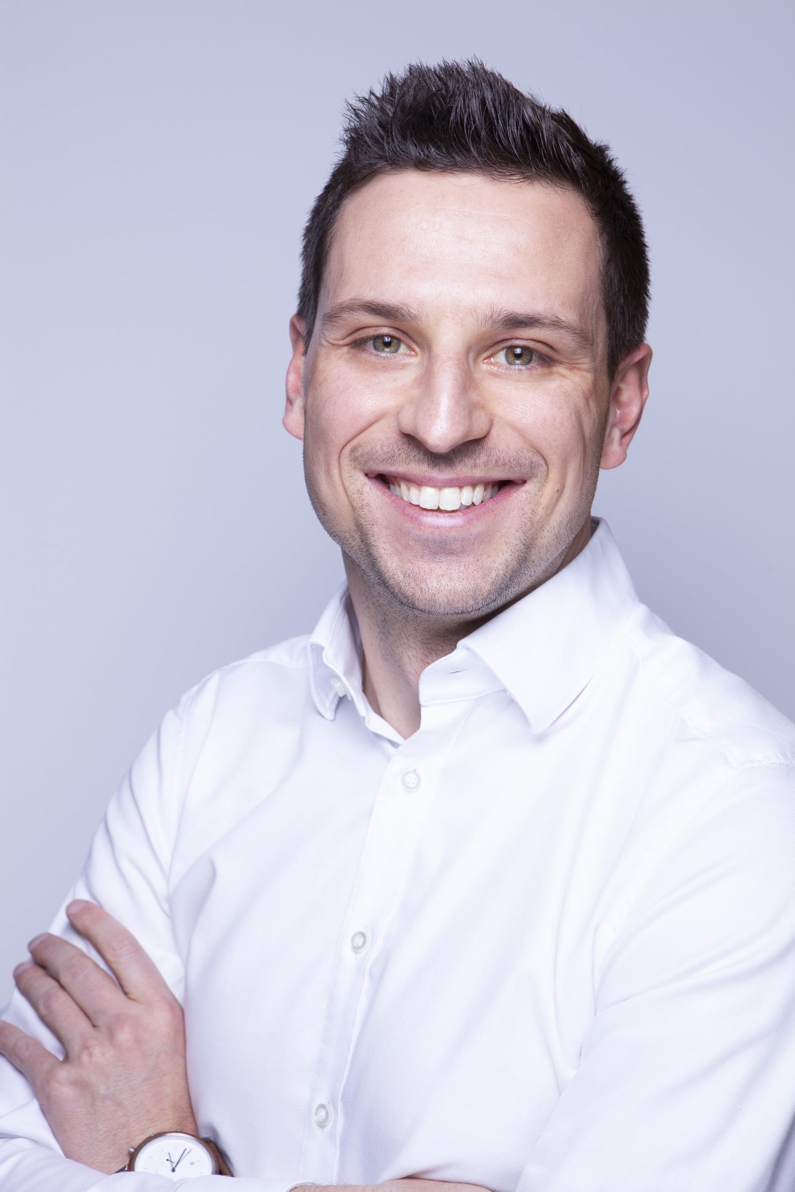 Robin Gollbach, CEO von freelance.de, ist ein junger Mann mit Kurzfrisur in weißem Hemd, der in die Kamera lächelt