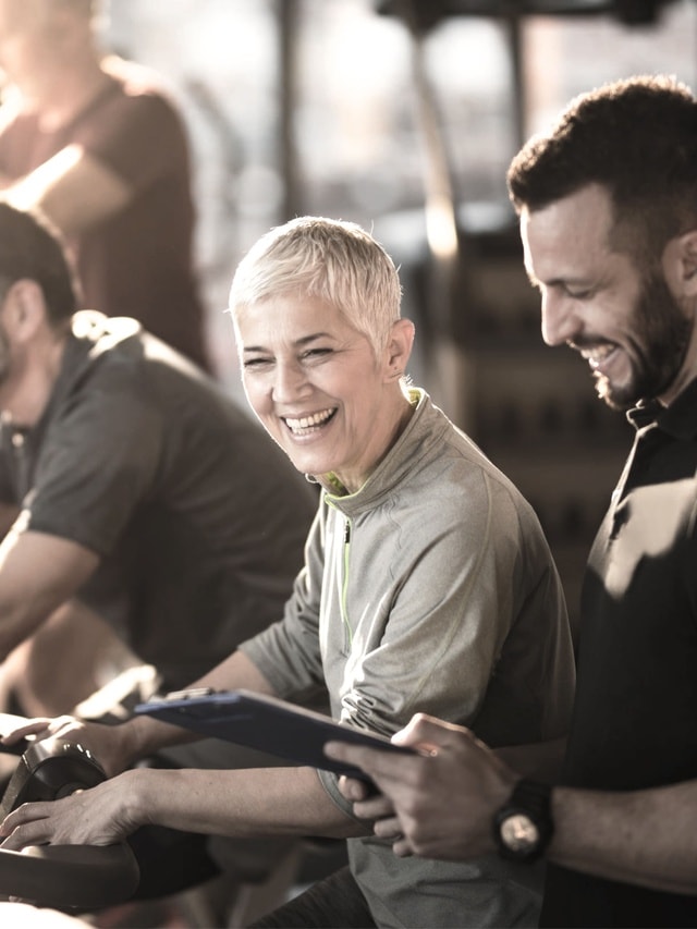 Trainer-Haftpflicht von Hiscox: Fitnesstrainer leitet seine Kundin beim Training an