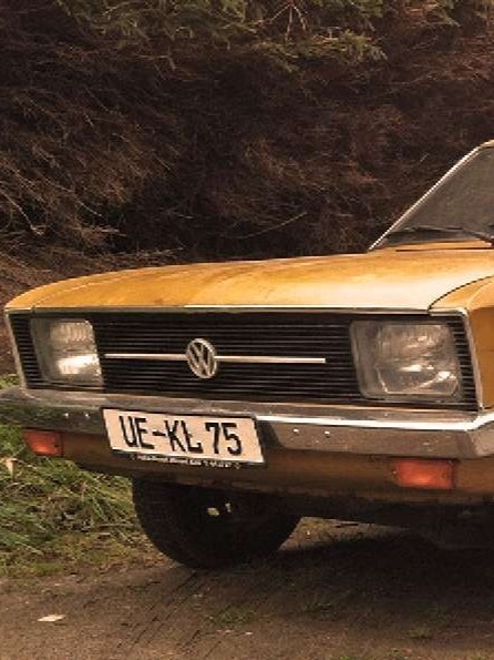 Goldener Volkswagen K70 L 1971 geparkt auf einer Straße im Wald
