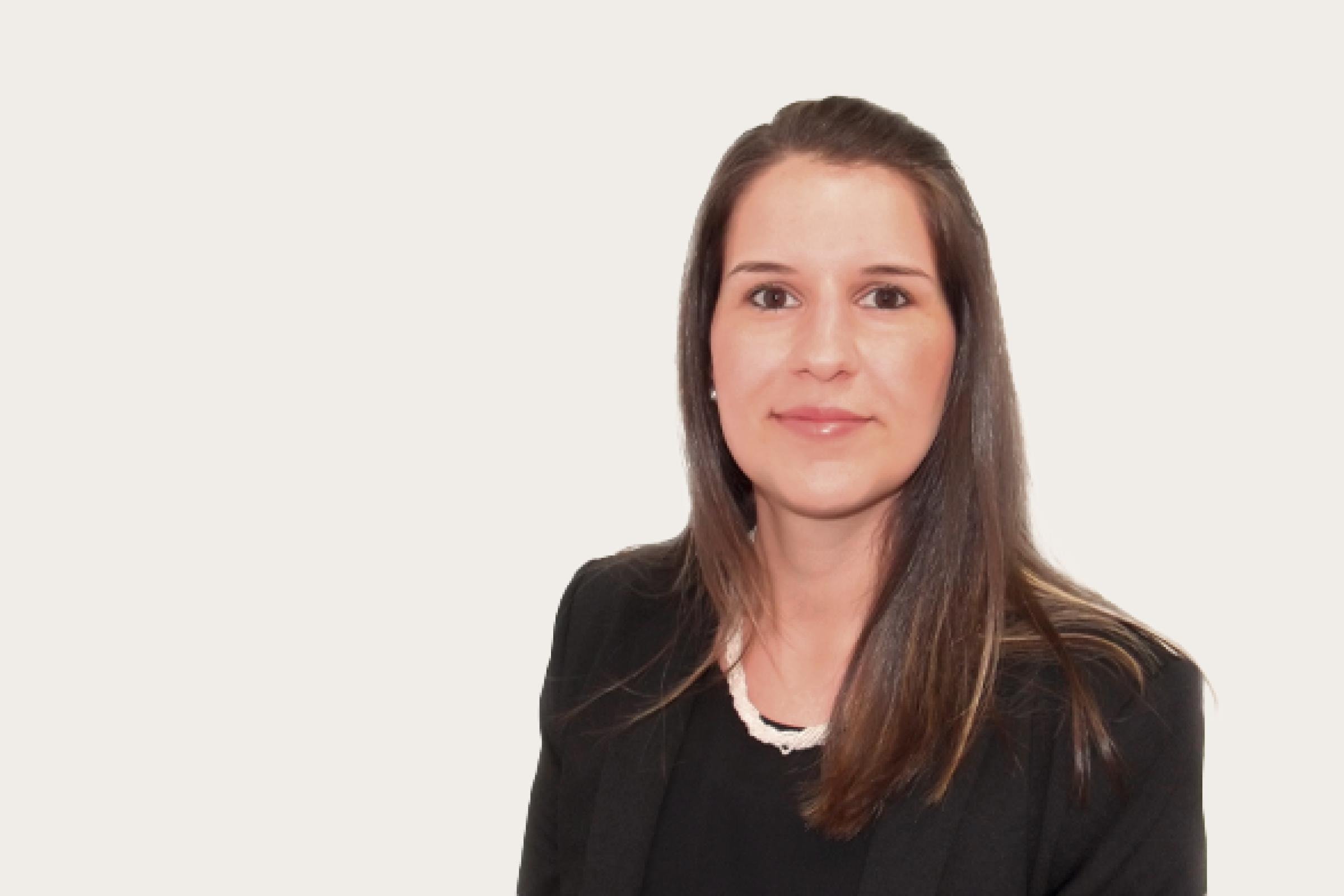 Tania Agostino, eine Frau mit langen braunen Haaren, trägt einen schwarzen Blazer und eine weiße Halskette.