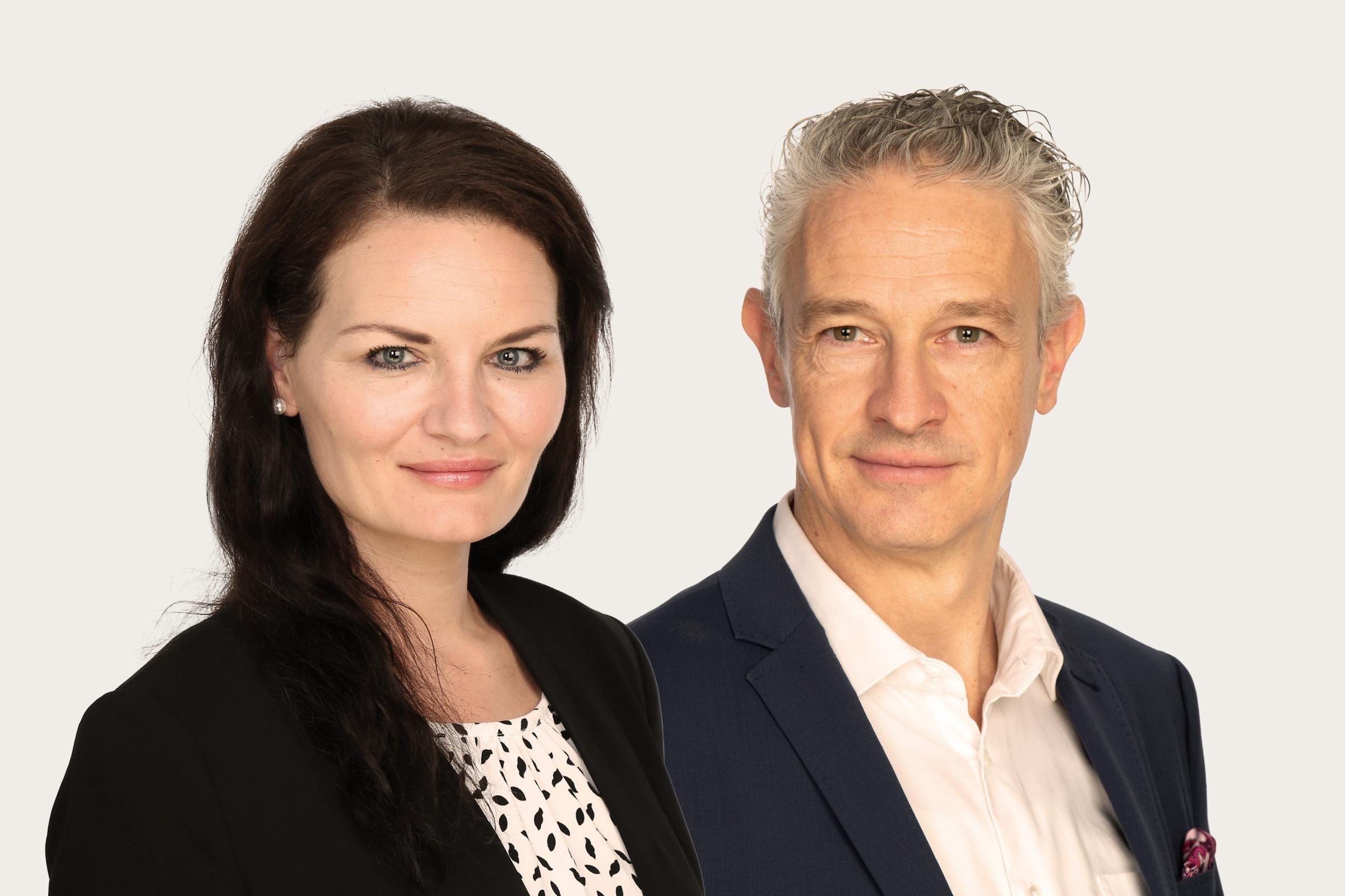 Patricia Baron trägt einen schwarzen Blazer, neben ihr ist Roman Potyka, der ein weißes Hemd und einen dunklen Blazer trägt