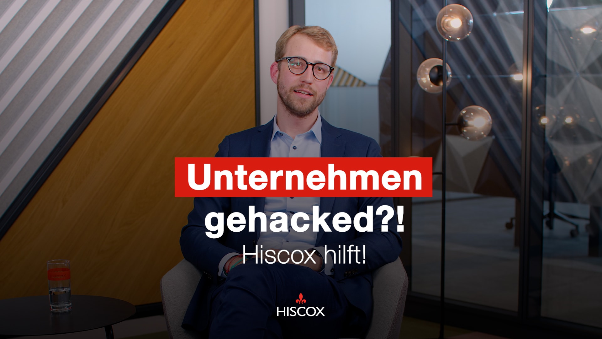 Vorschaubild des Videos zum Cyber-Angriff eines Unternehmens, auf dem der Hiscox Underwriter Bastian Lutz vor der Kamera sitzt