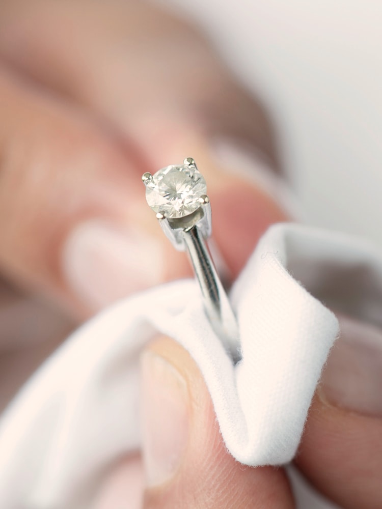Ein Diamantring, der mit einem Tuch poliert wird