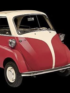 Ein klassisches Mikroauto, ein BMW Isetta, mit roter Karosserie und weißen Akzenten. Es hat eine nach vorne öffnende Tür und kleine runde Scheinwerfer.