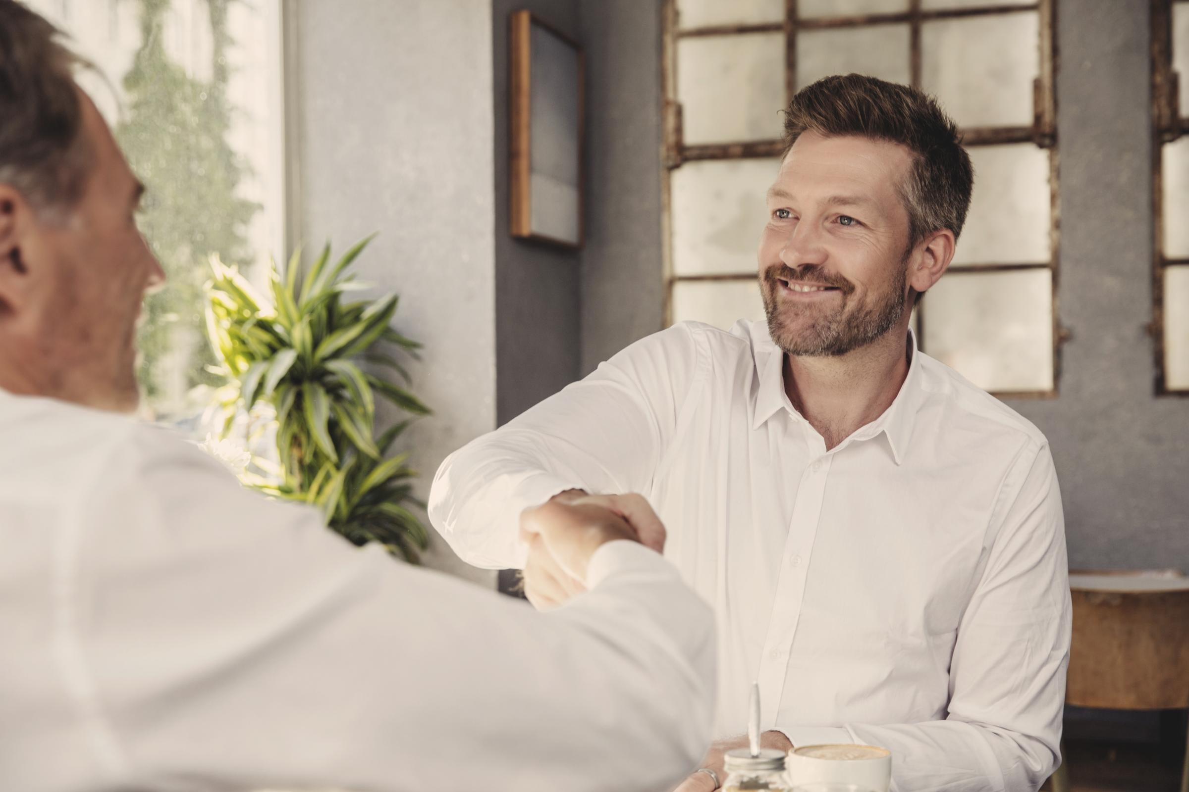 Hiscox Versicherung über Makler abschließen: Zwei Männer reichen sich die Hände