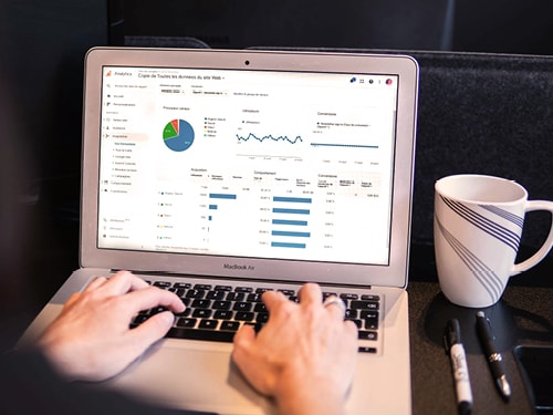 Ansicht eines Laptops, an dem ein Mann einen Google Ads Kampagne bearbeitet