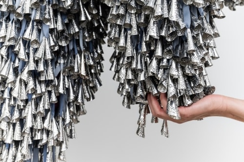 Textile Installation Thirteen Moons (2025) von Marie Watt mit dicht gehängten silbernen und blaugrauen Elementen