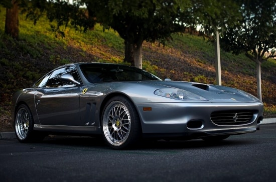 Ferrari 550 Maranello in silber vor Park-Hintergrund in schräger Frontansicht