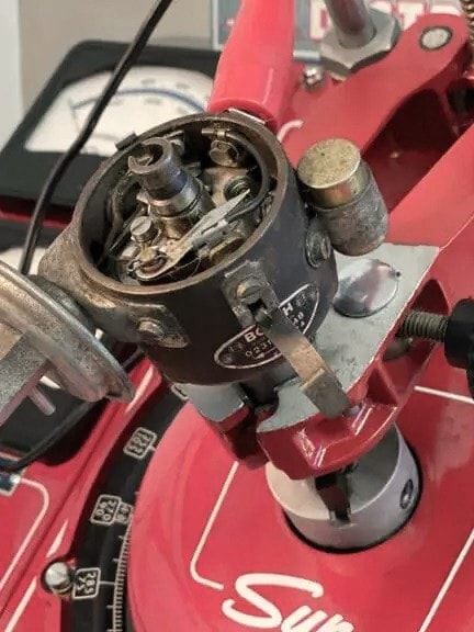 Nahaufnahme eines Vintage-Sun-Verteilertestgeräts mit verschiedenen Zifferblättern und Messgeräten zur Kalibrierung von Automobilverteilern.