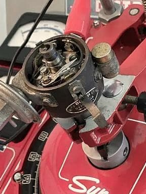 Nahaufnahme eines Vintage-Sun-Verteilertestgeräts mit verschiedenen Zifferblättern und Messgeräten zur Kalibrierung von Automobilverteilern.