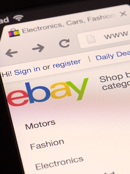 Finger zeigt auf die geöffnete Startseite von eBay im Browser auf den Button "Shop by category"