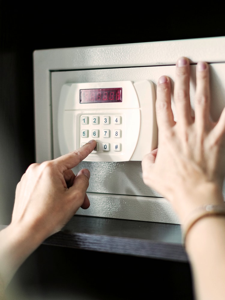 Eine Frau gibt einen Zahlencode in einem Tresor ein