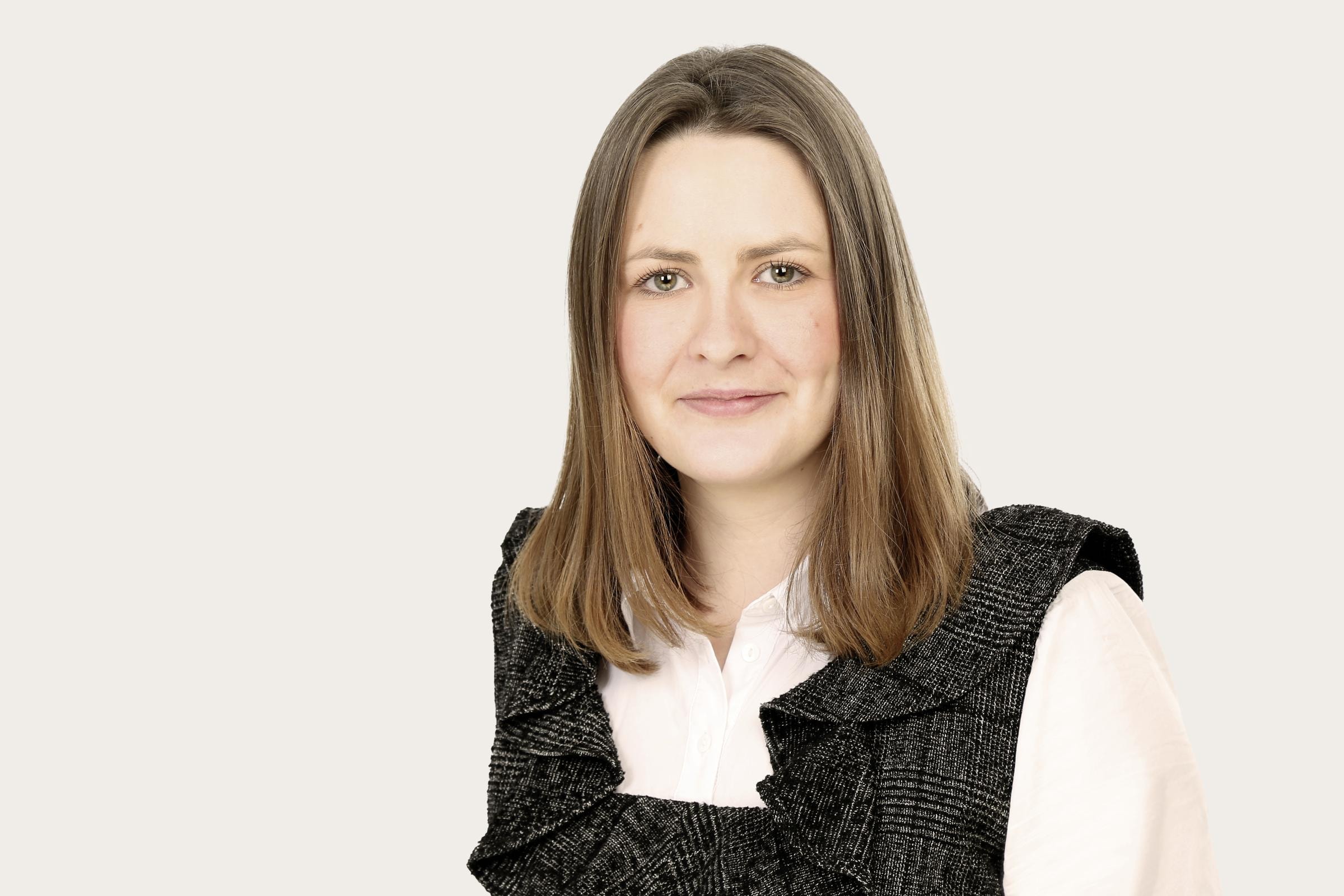 Friederike Fabry, Project Manager Digital Transformation, lächelt in die Kamera. Sie hat braune schulterlange Haare und trägt eine weiße Bluse