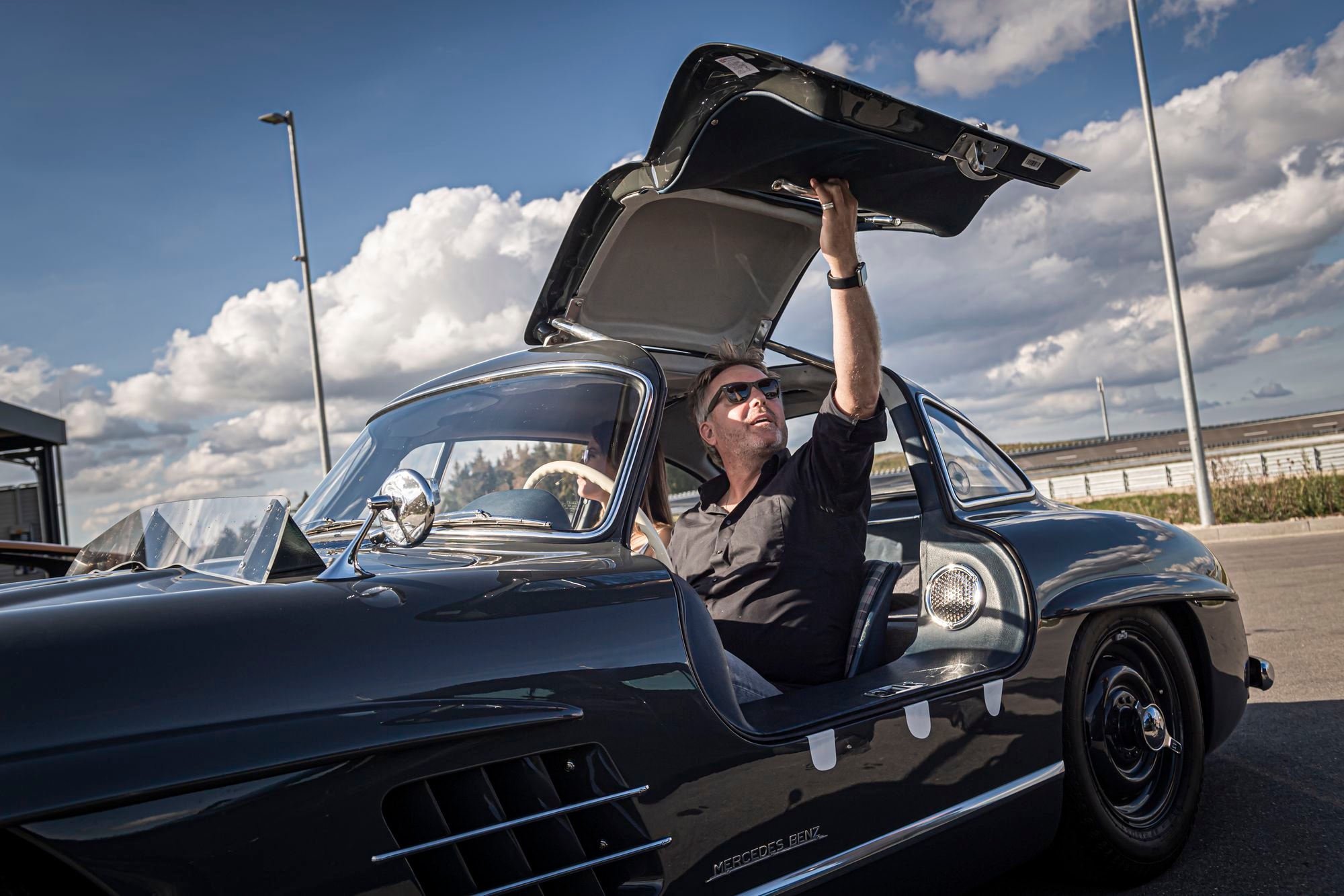 Flügeltür des parkenden Mercedes Benz 300 SL wird von Jens Tanz geöffnet