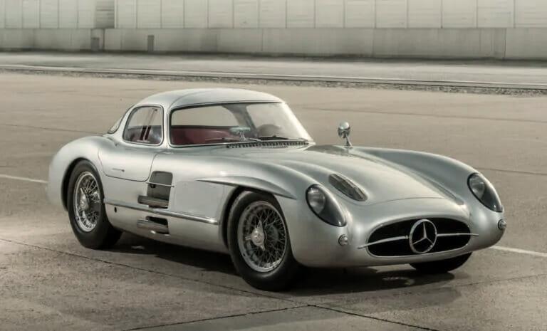 Ein klassischer silberner Mercedes-Benz 300 SLR Uhlenhaut Coupé, der auf einer Betonfläche geparkt ist.