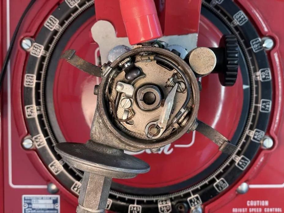 Nahaufnahme eines Verteilers auf einem roten Testgerät. Sichtbar sind interne Komponenten wie Rotor, Kontakte und Kondensator.