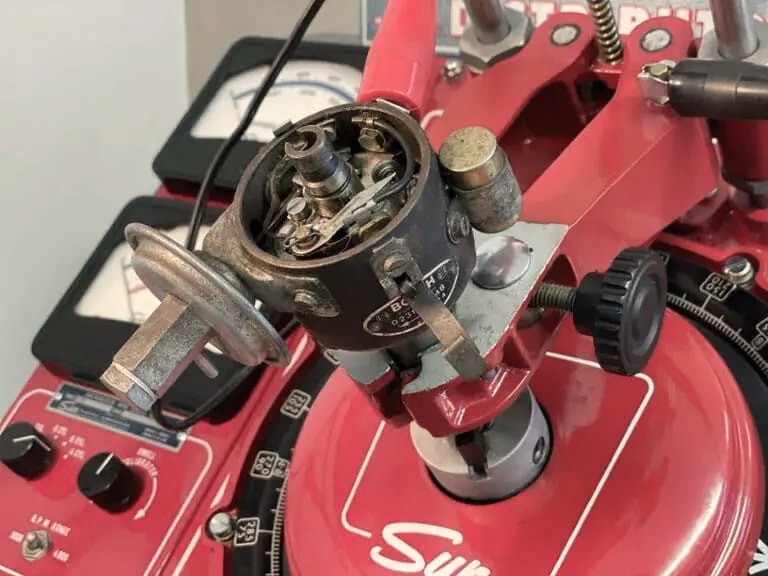 Nahaufnahme eines Vintage-Sun-Verteilertestgeräts mit verschiedenen Zifferblättern und Messgeräten zur Kalibrierung von Automobilverteilern.