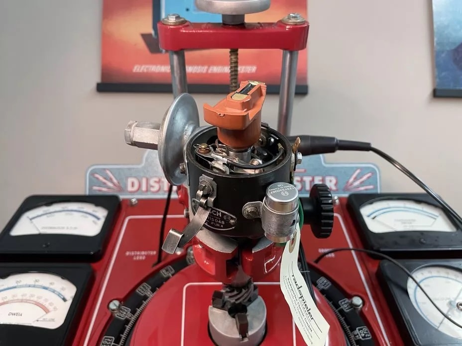 Verteilerprüfgerät mit montiertem Verteiler und mehreren Messgeräten und Zifferblättern zur Leistungsprüfung.