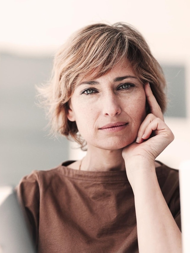 Versicherungen für Privatkunden von Hiscox: Frau blickt zufrieden in die Kamera