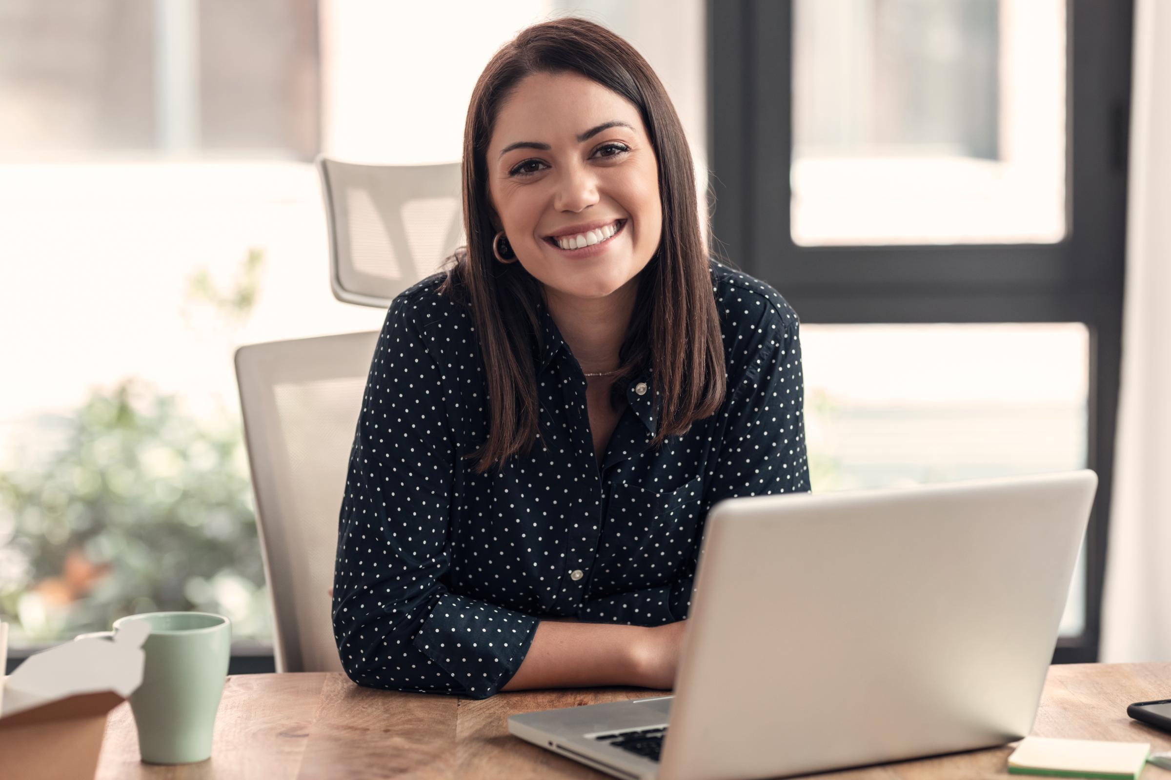 Lächelnde Frau am Laptop im Homeoffice: Positive Arbeitsatmosphäre und berufliche Kommunikation