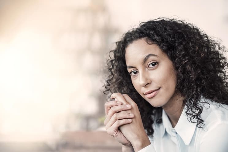 Versicherungen für Freelancer und Unternehmen: Frau blickt lächelnd in die Kamera