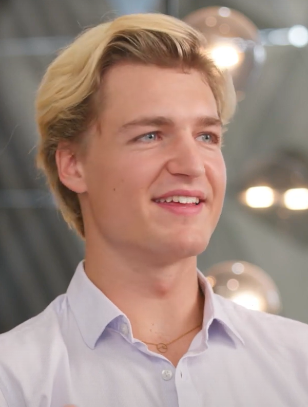 Hiscox Underwriter Nils Woyna ist ein blonder junger Mann, der auf dem Bild lächelt.