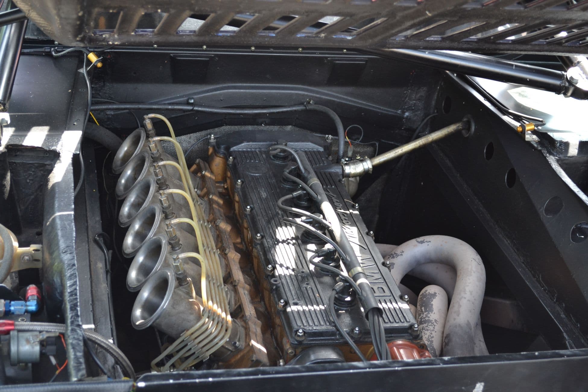Der Motor des BMW M1 ist sichtbar, umgeben von verschiedenen Komponenten und Kabeln.