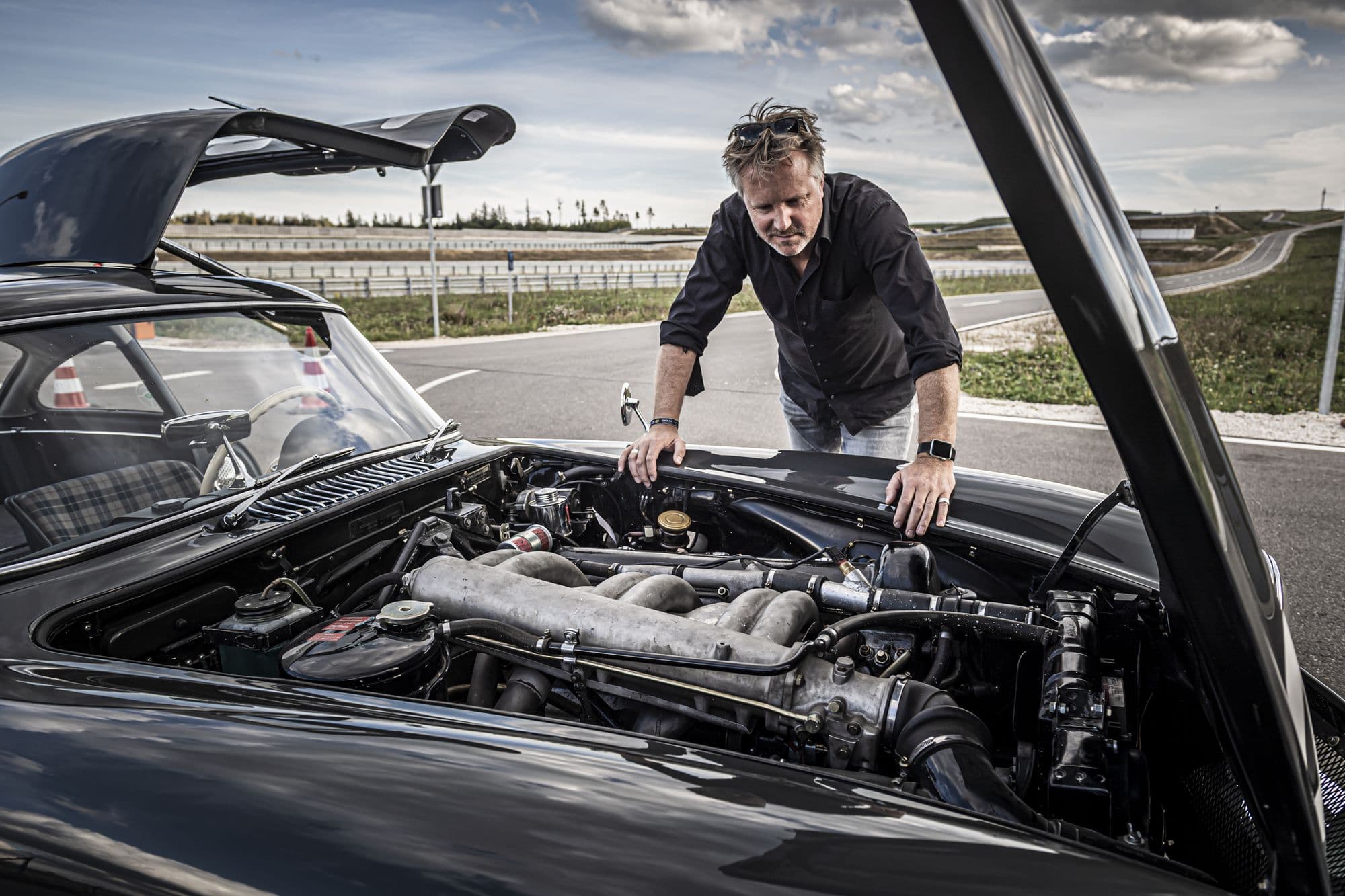 Jens Tanz schaut in offene Motorhaube des Mercedes 300 SL Flügeltürers