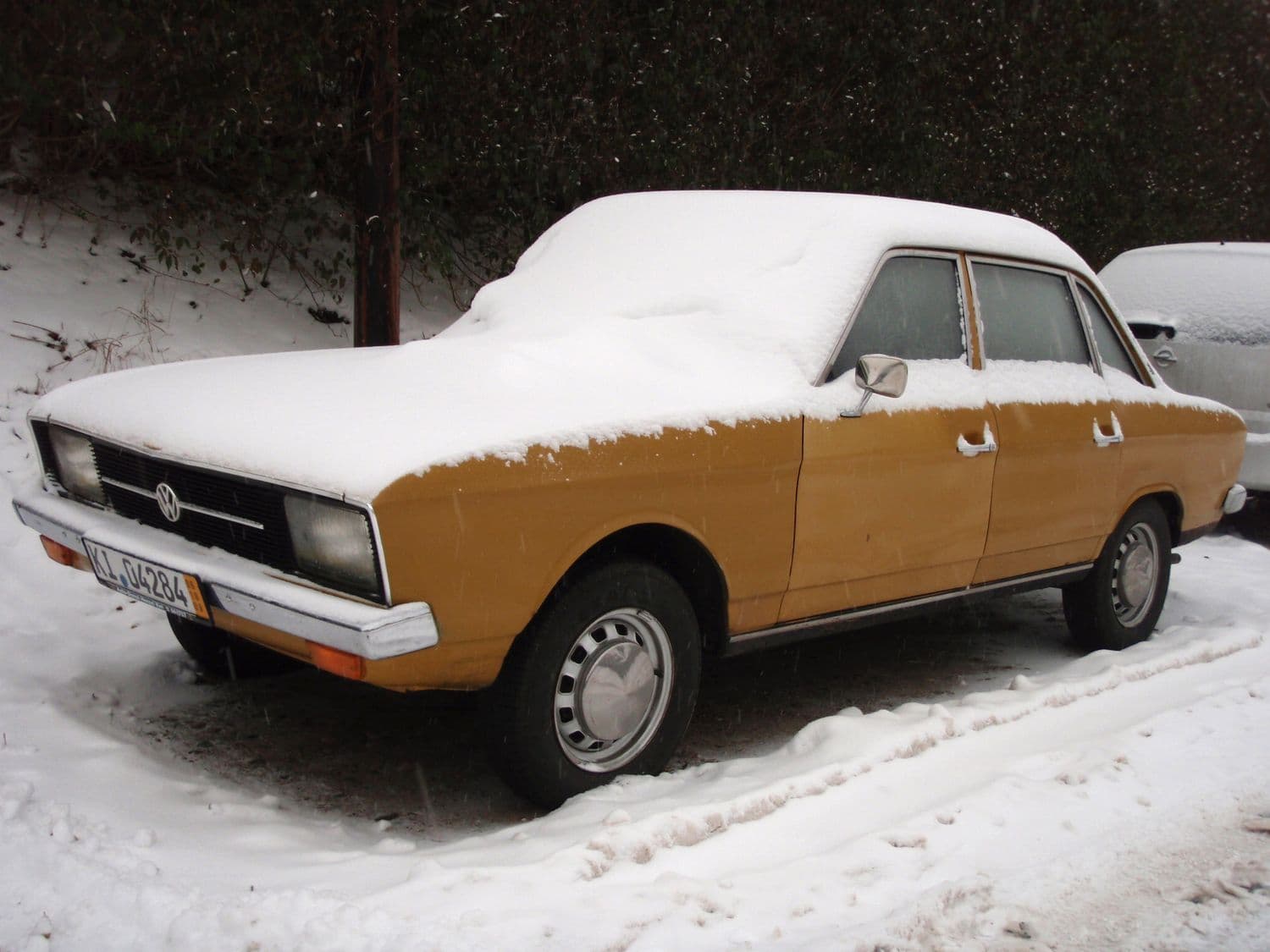 Der VW K 70 L 1971 Oldtimer im Winter bedeckt mit Schnee parkend am Straßenrand